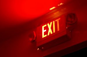 Emergency exit sign glowing in a dark hallway